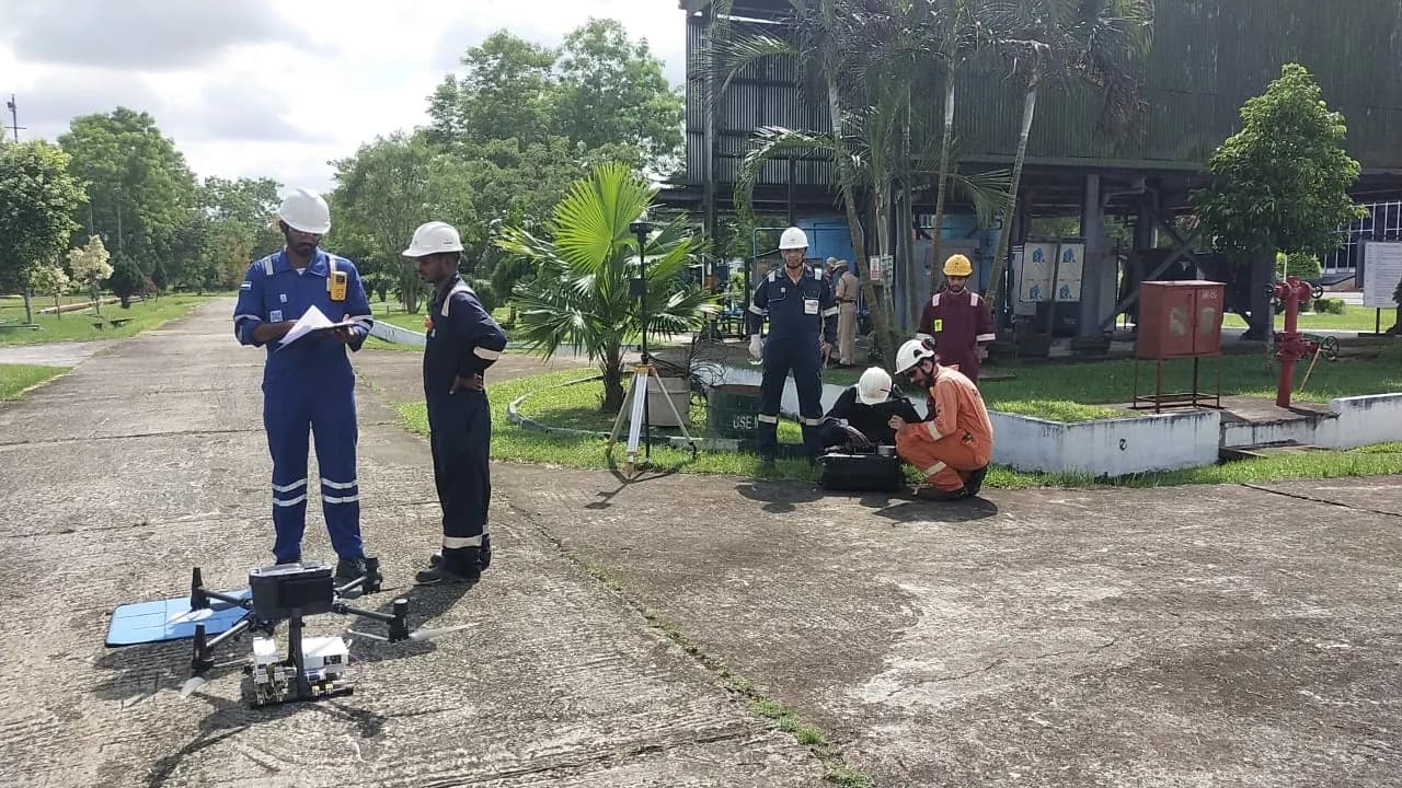 The UNITOS flight crew preparing the aircraft on a refinery apron beside a Total Station.